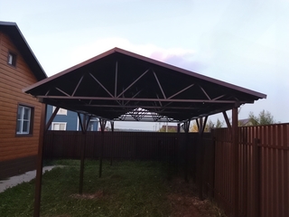 Двускатный коричневый навес с крышей из профлиста для загородного дома